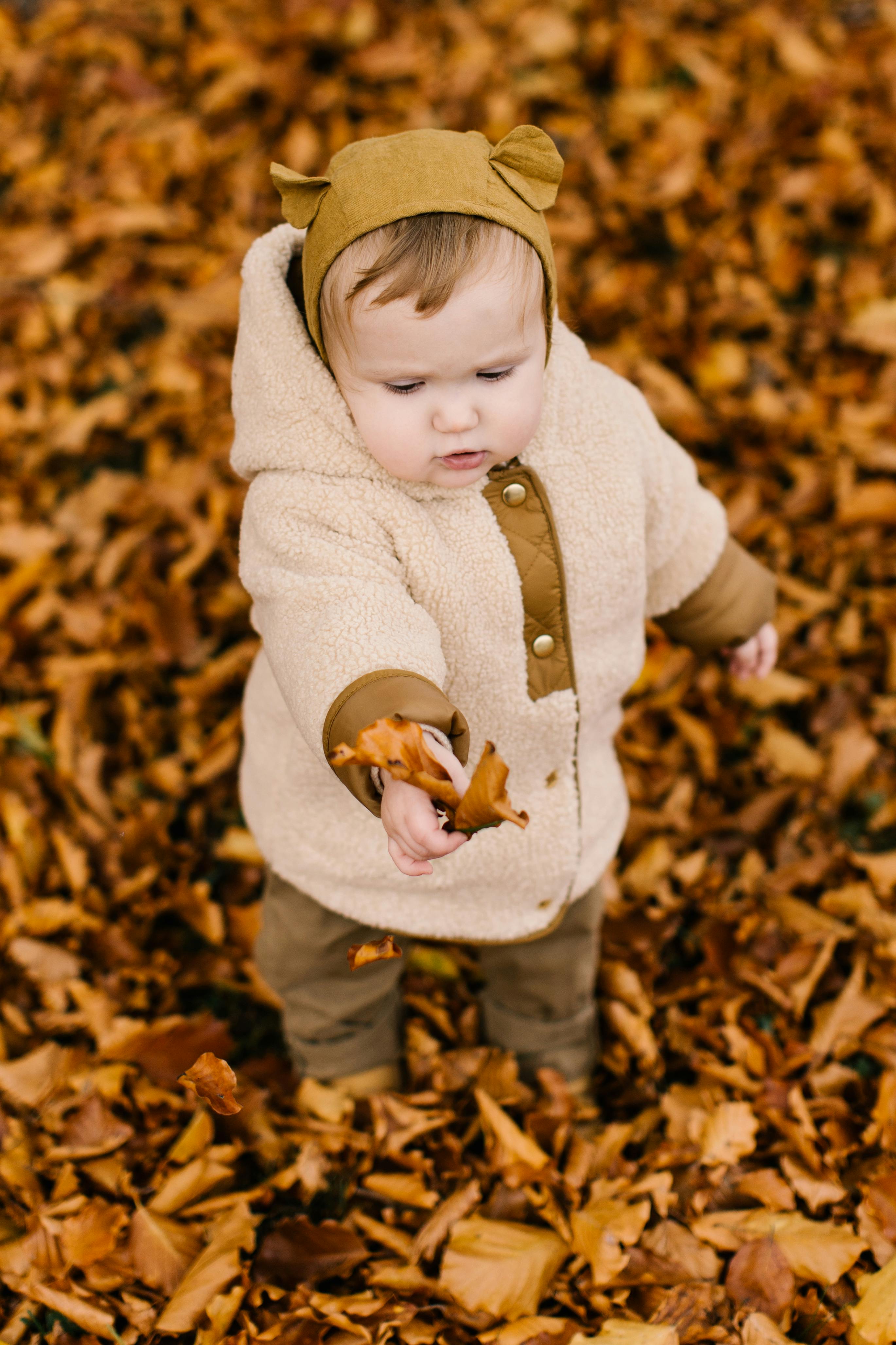 photo of child holding dried leaves