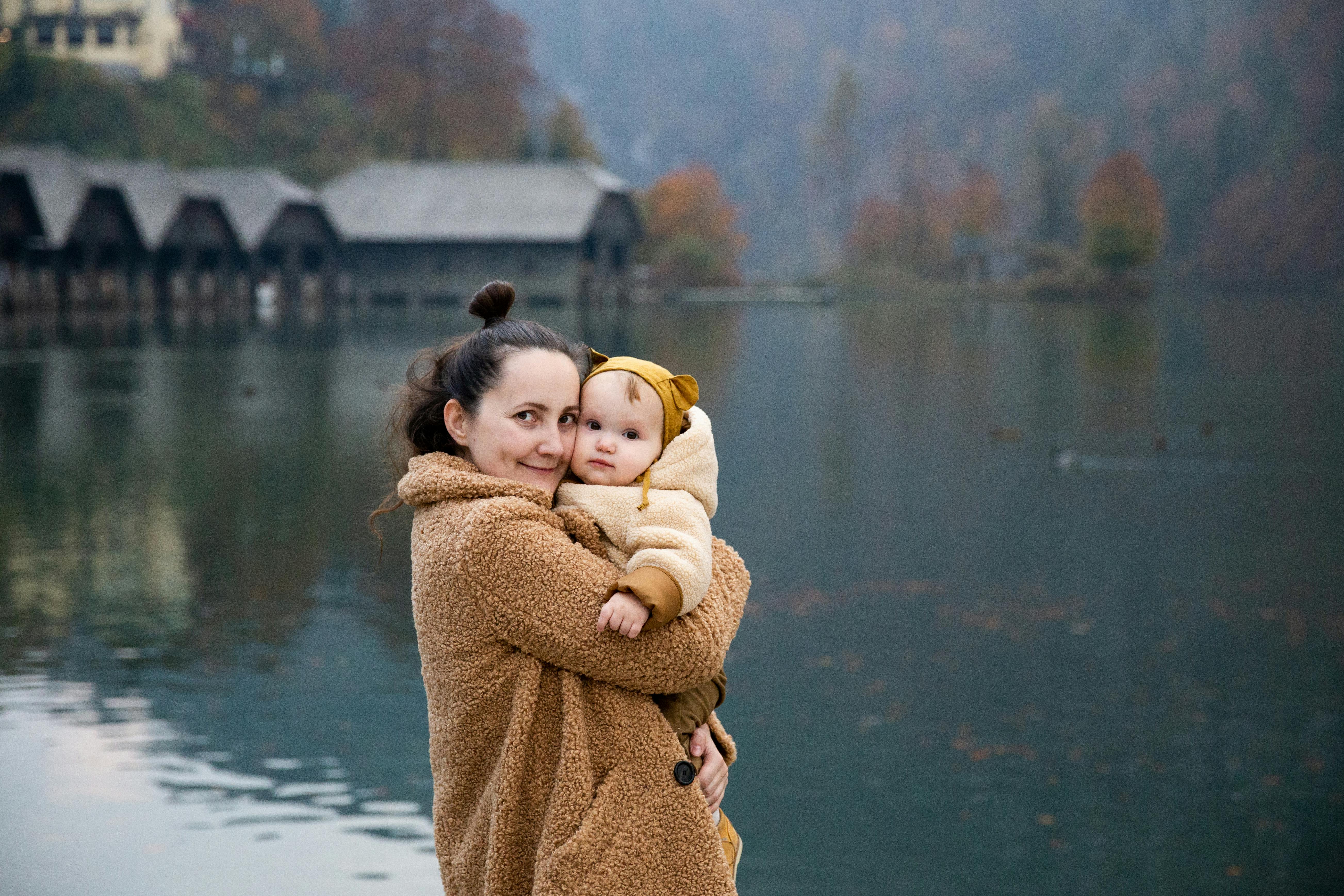 photo of woman hugging baby