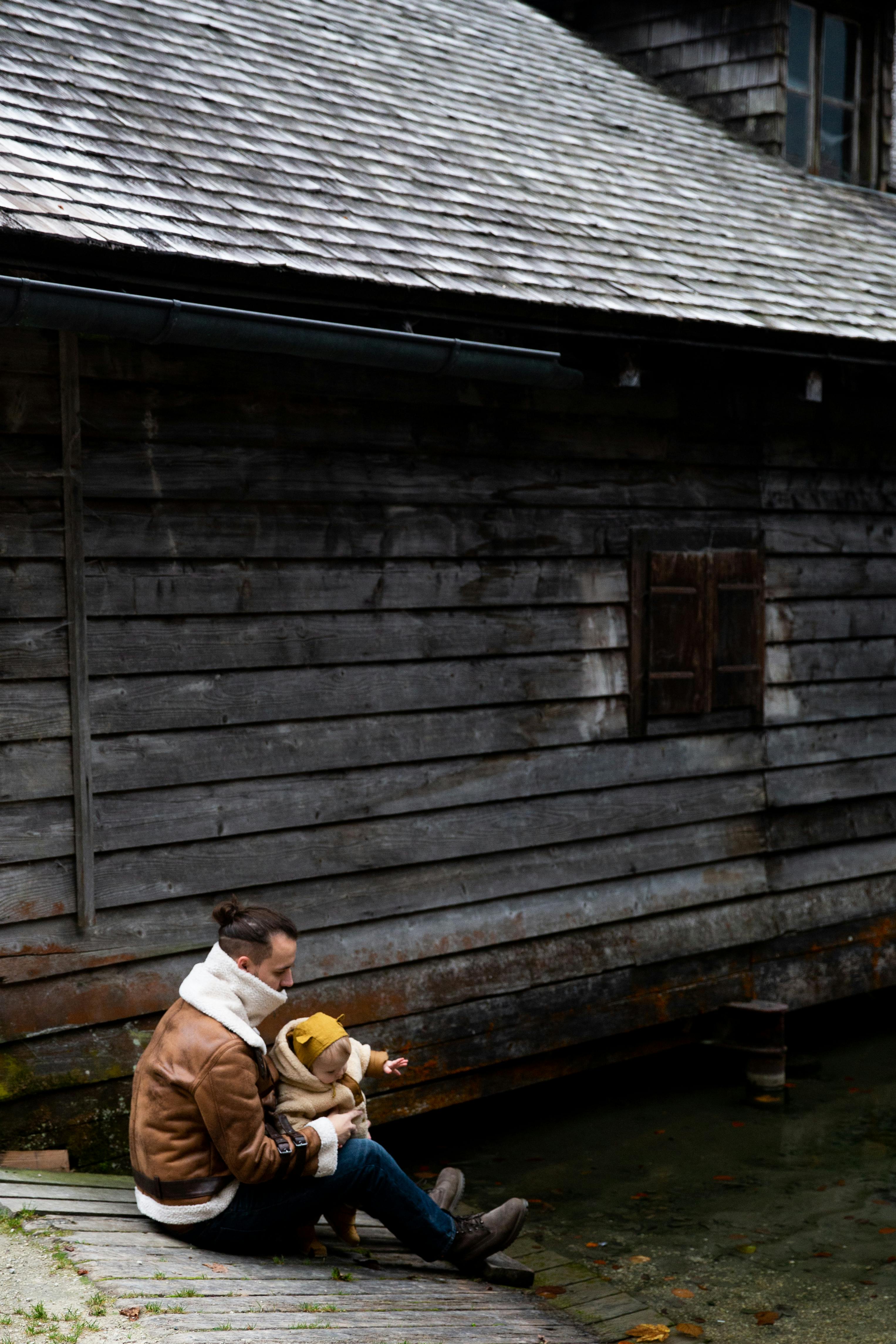 photo of man carrying baby