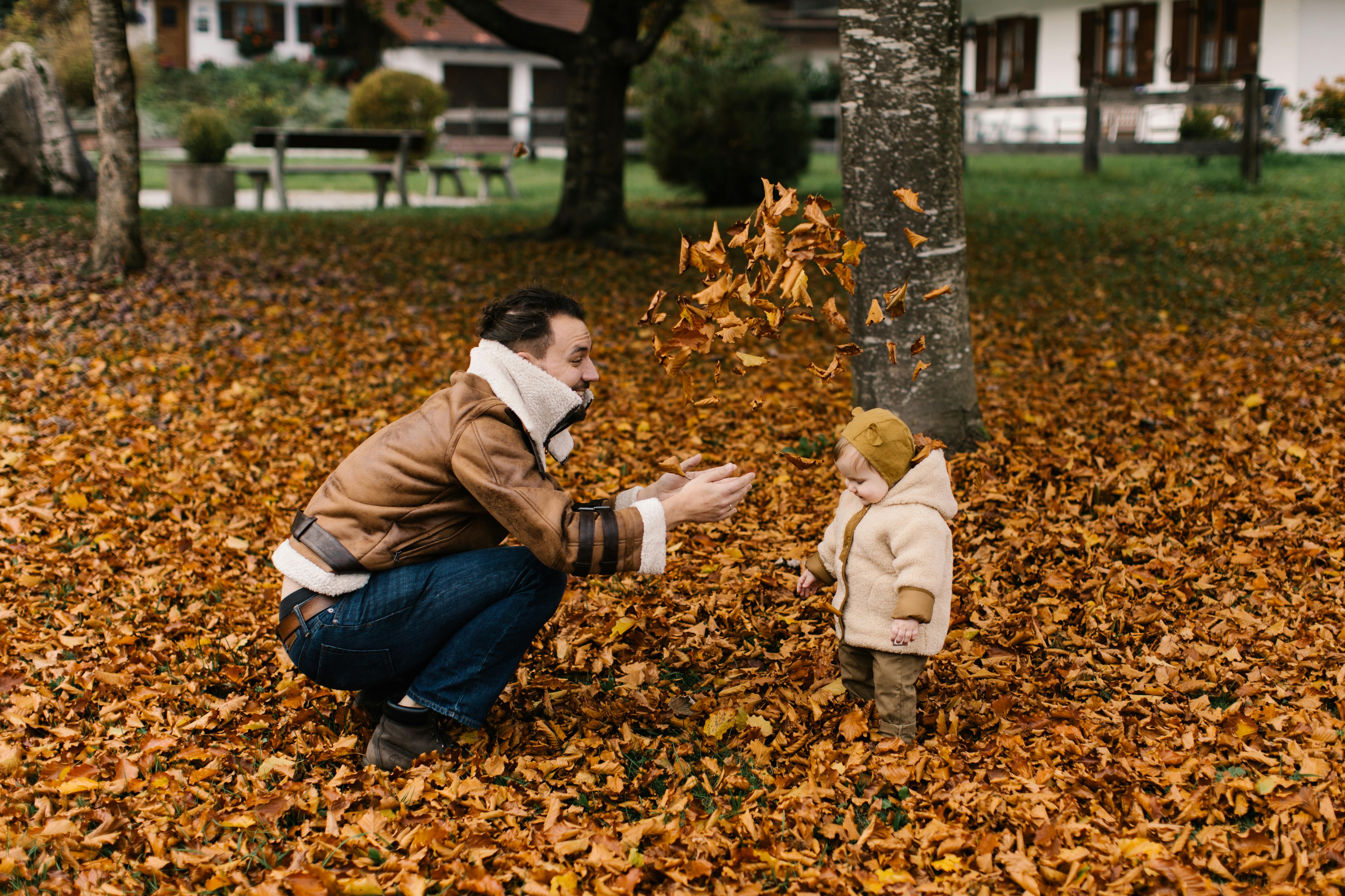 photo of man playing with baby