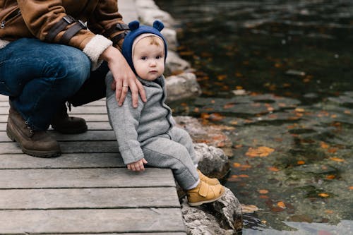 Photo Of Toddler Sitting On Wooden Dock 