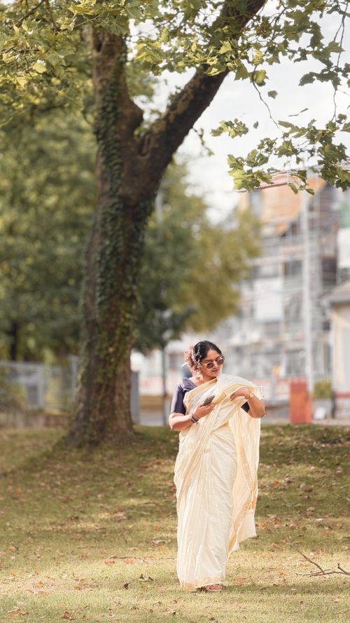 Free Woman in a white saree strolling through a park in Gießen, Germany. Stock Photo