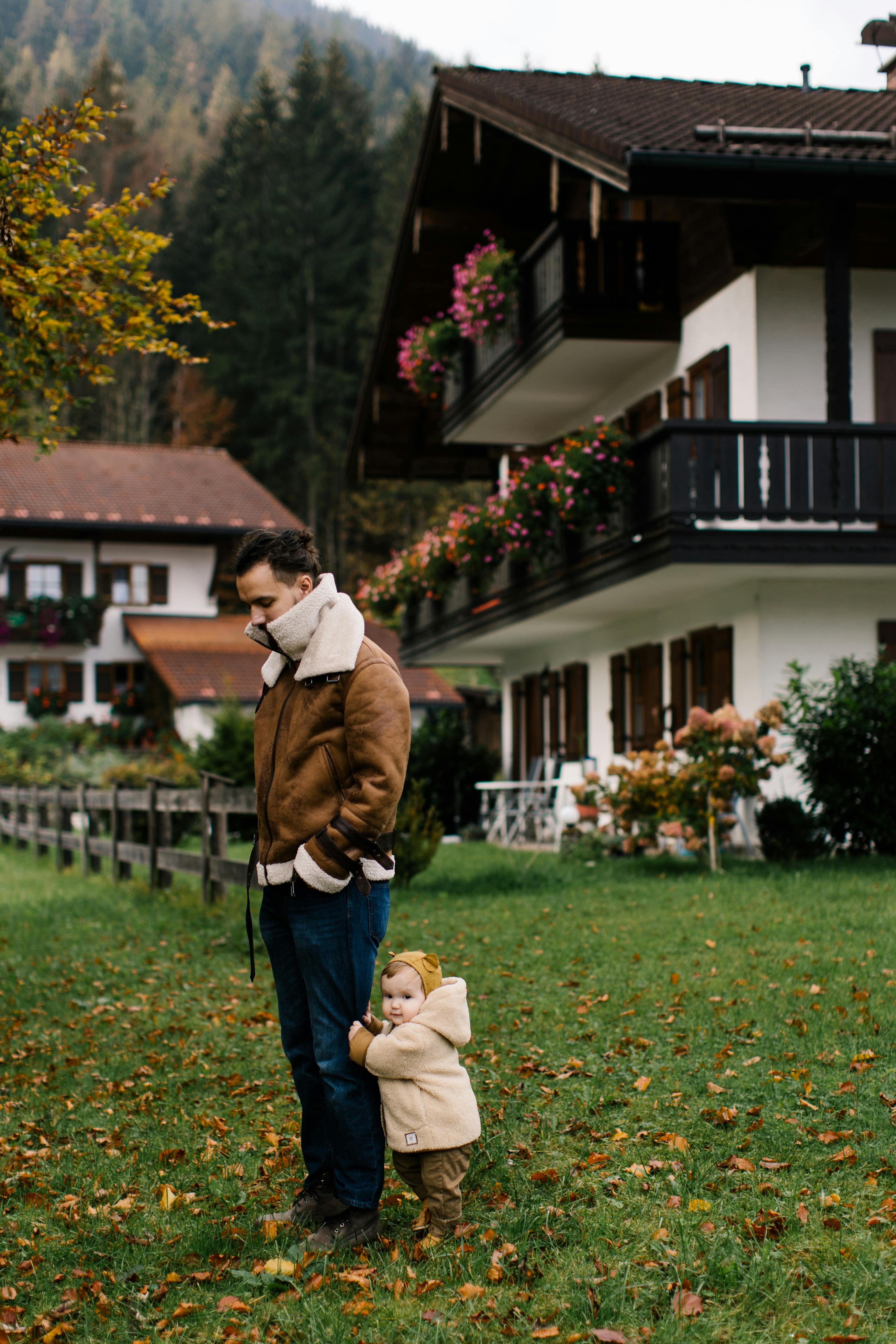 photo of baby holding man s pants