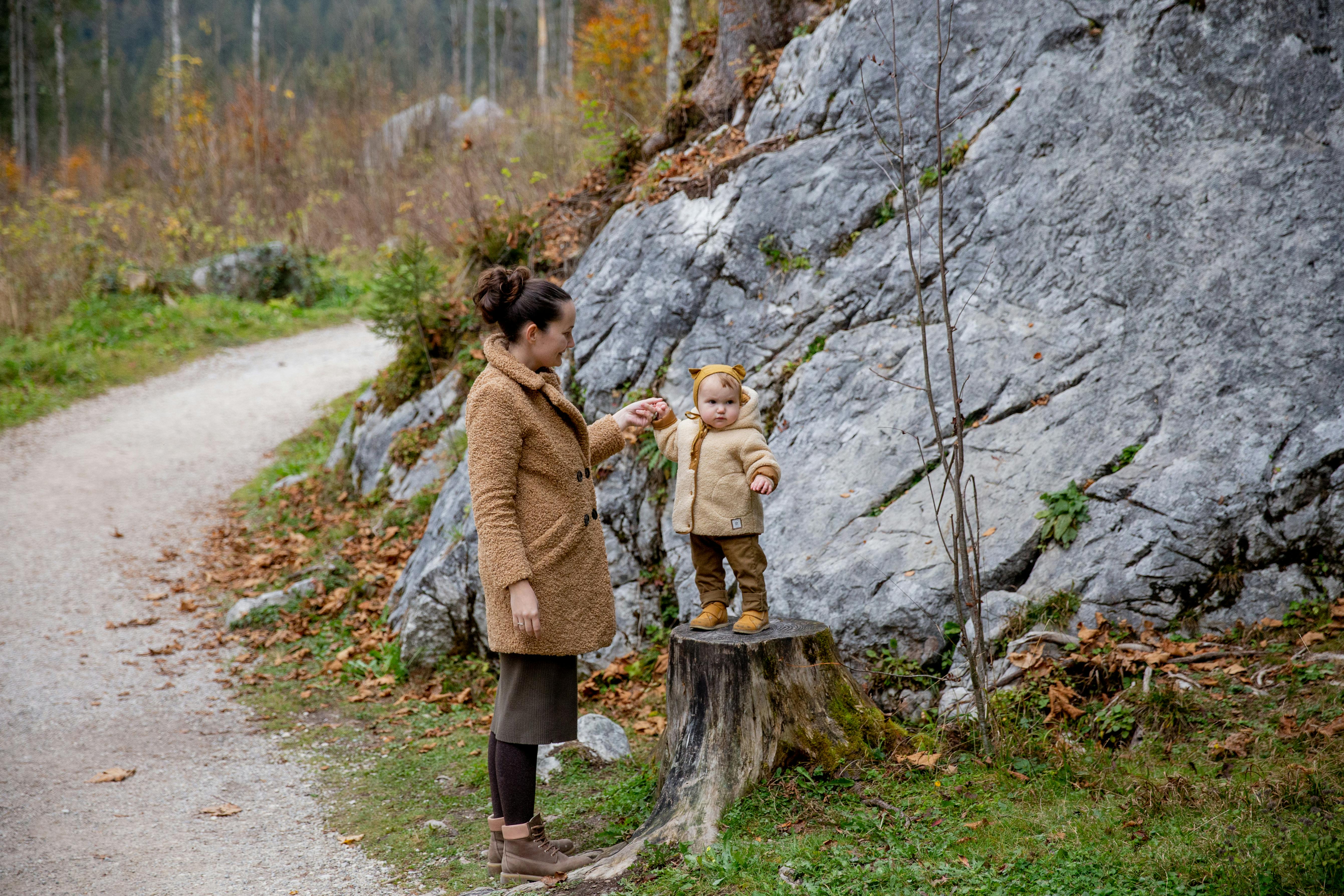 photo of woman holding baby s arms