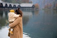 初秋，一位母亲和孩子在宁静的湖边与船屋共度温柔时光