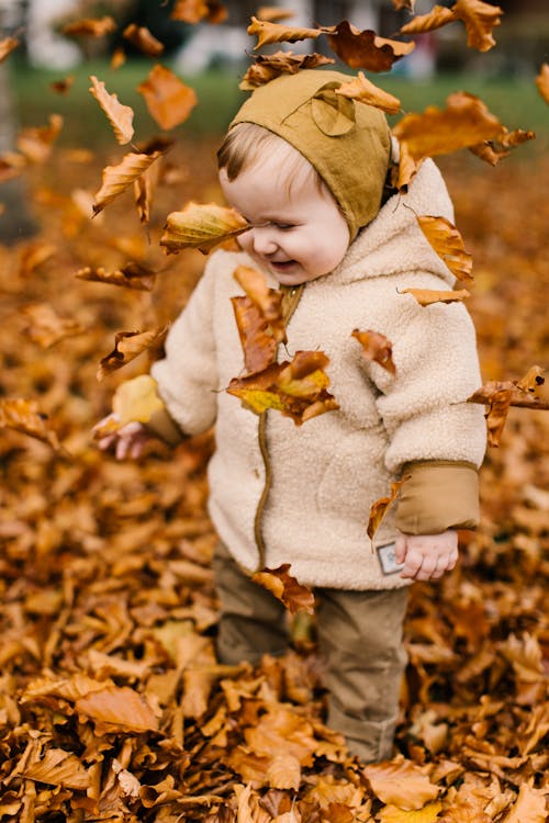 Photo Of Baby Playing With Dried Leaves