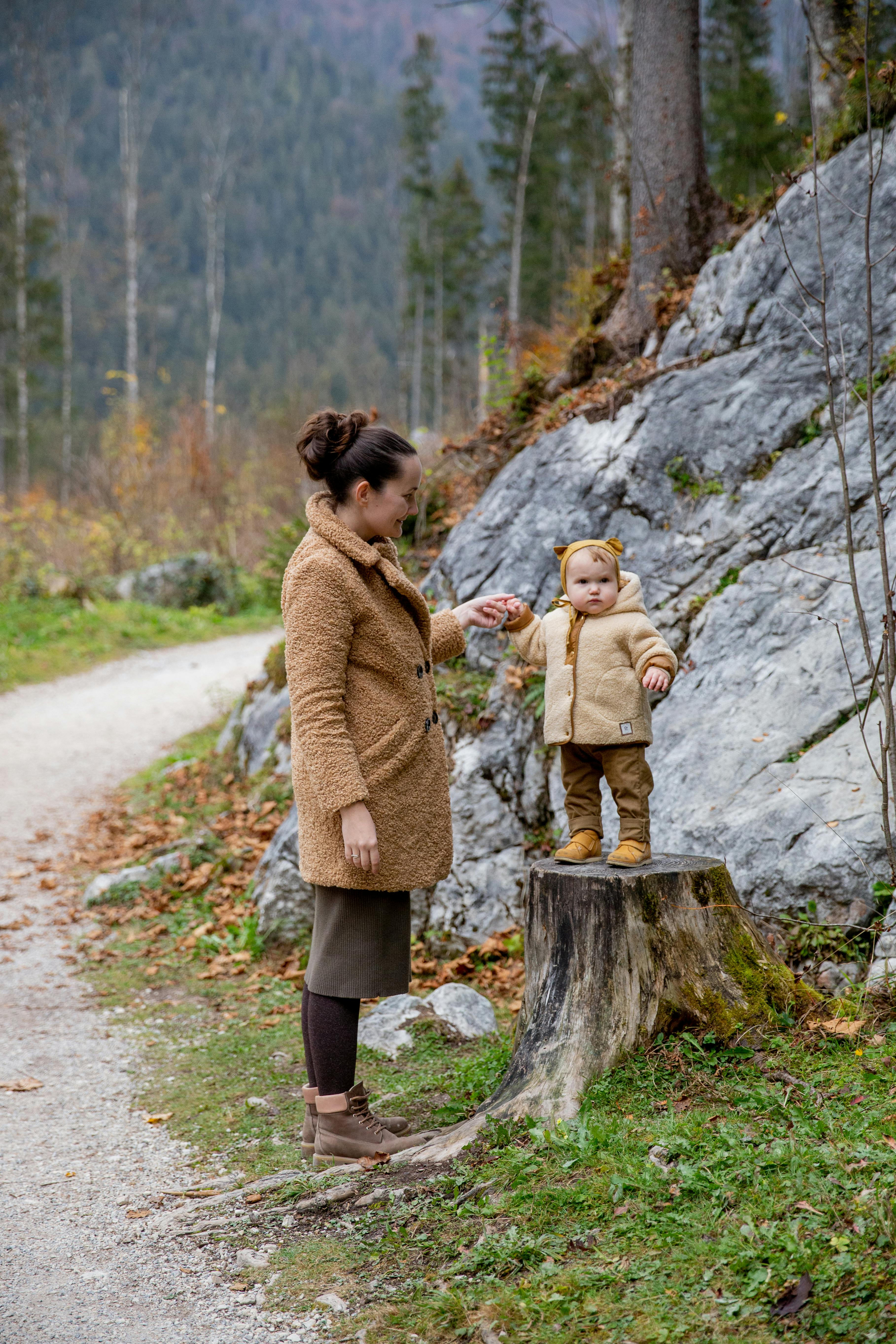 photo of baby standing on tree log