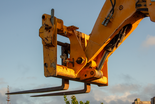 Free Detailed view of a forklift attachment under a clear sky at sunset. Stock Photo