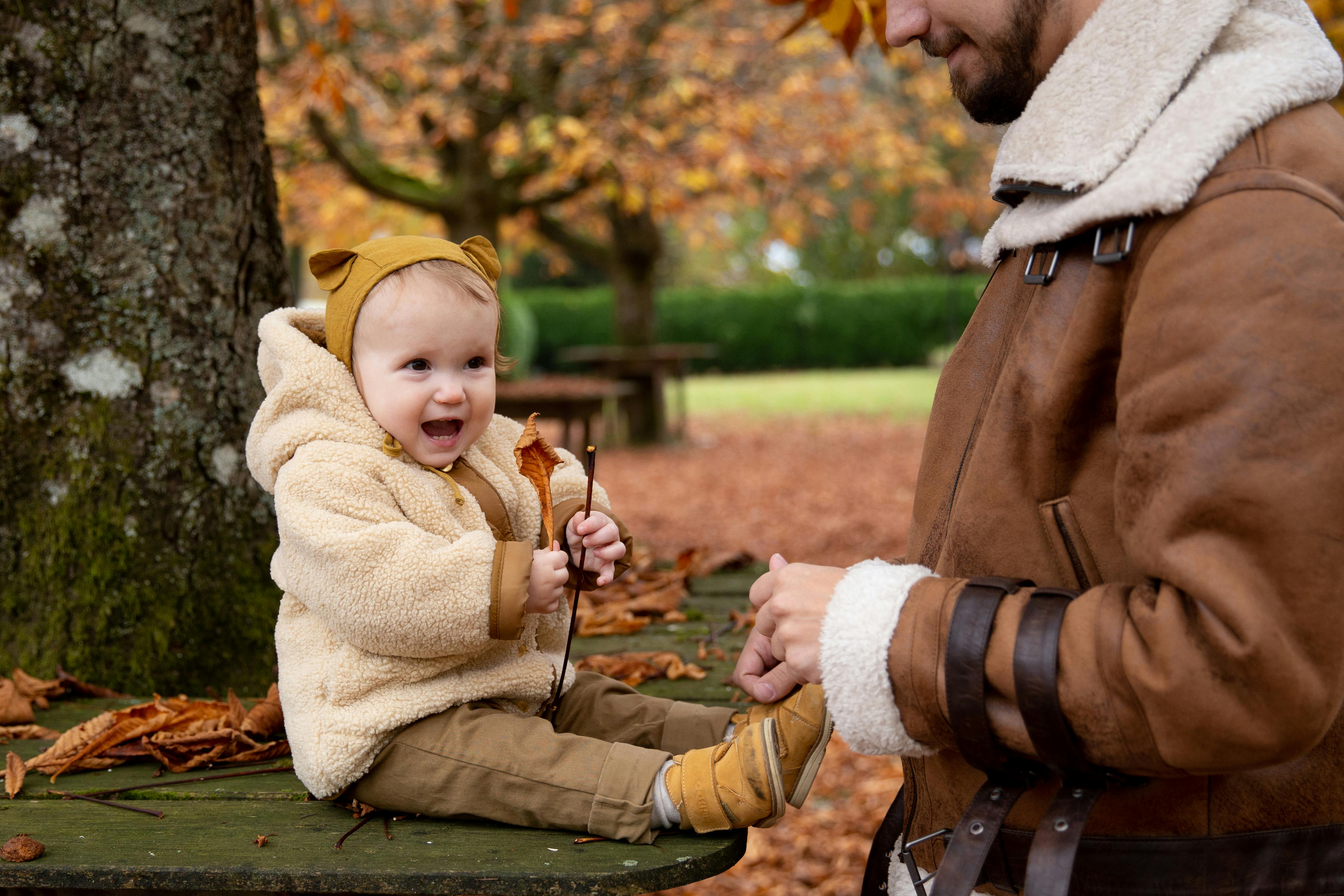 photo of child sitting on wooden surface