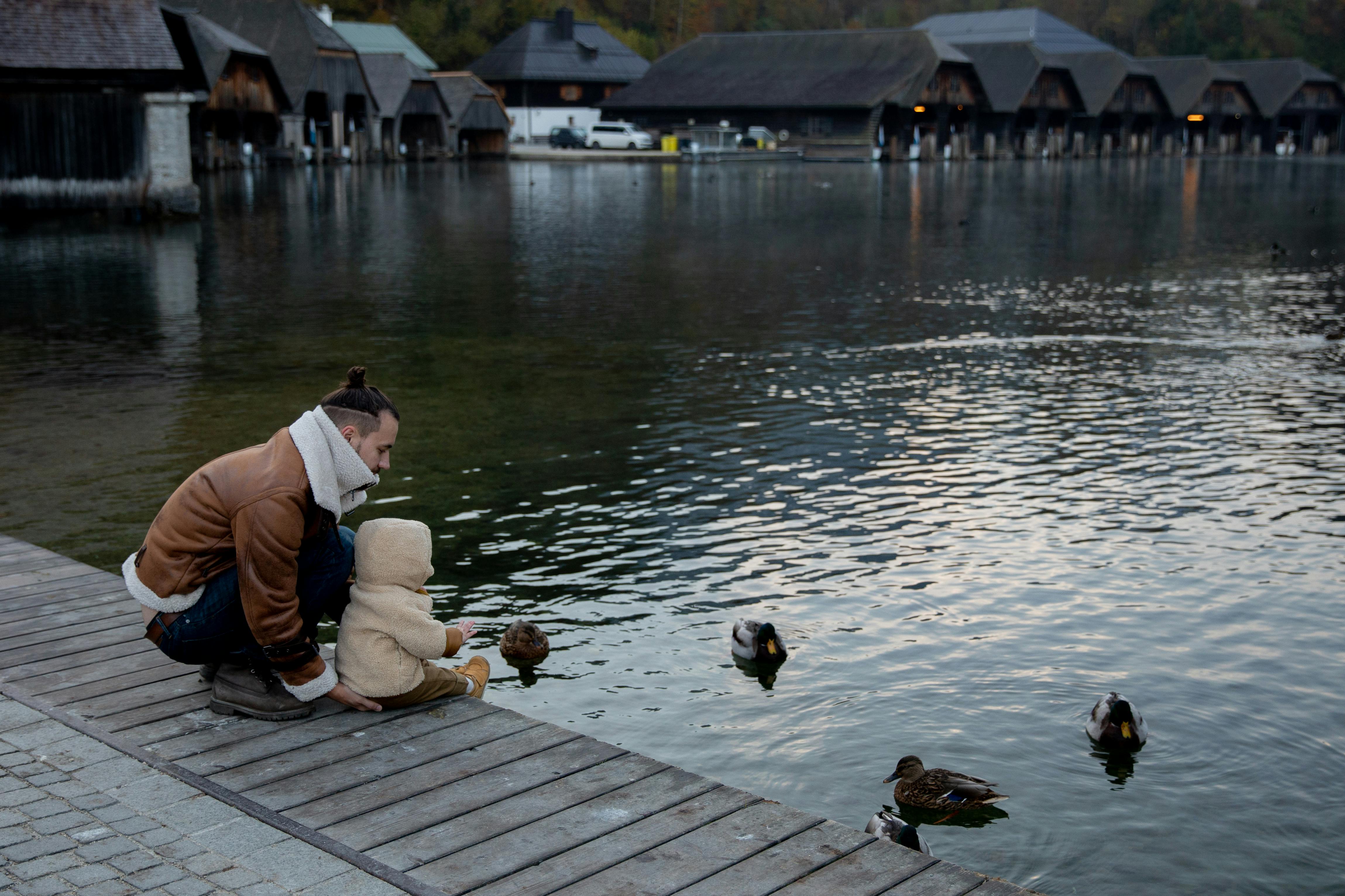 photo of baby sitting on wooden dock