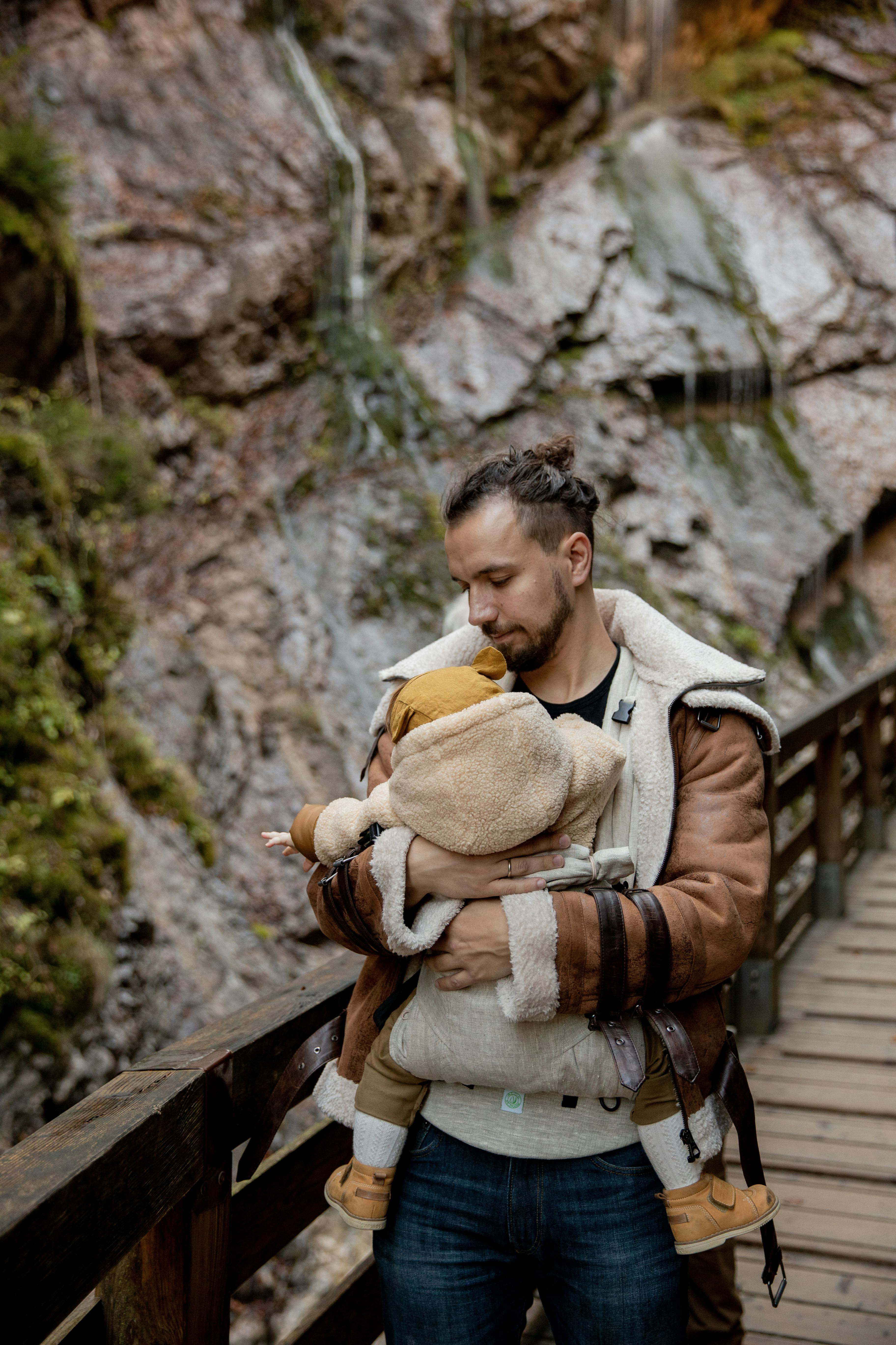 photo of man carrying baby