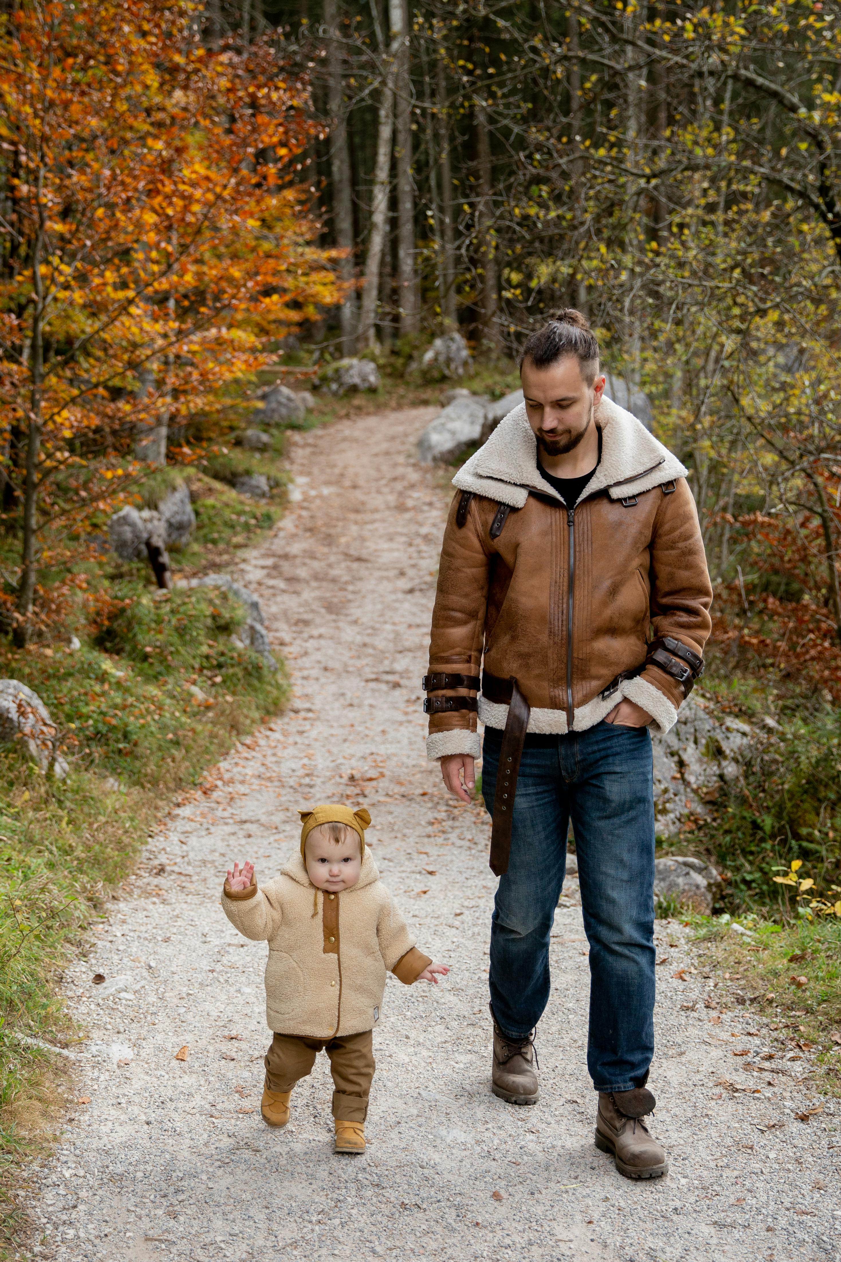 photo of man walking beside child