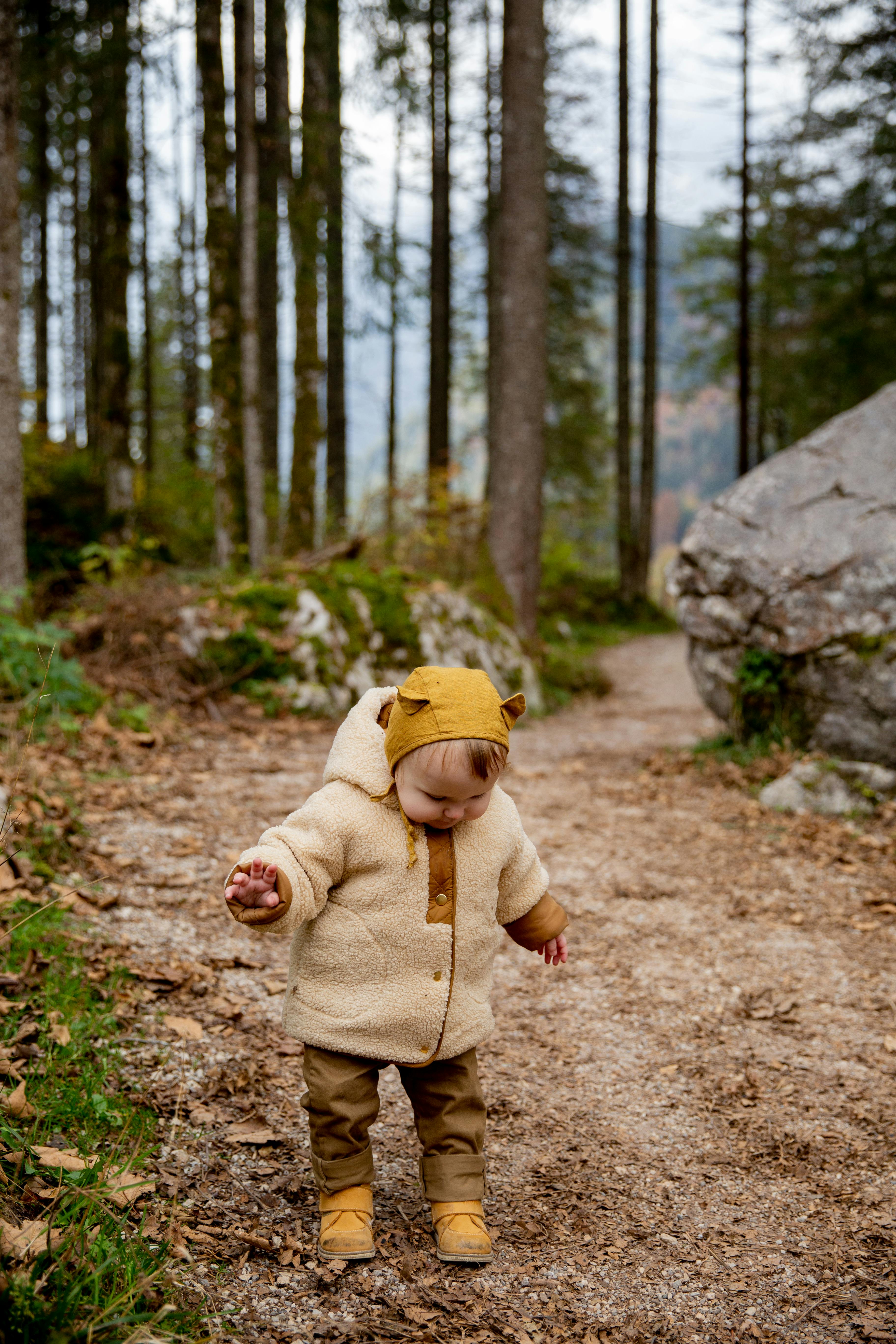 photo of baby standing on dirt road