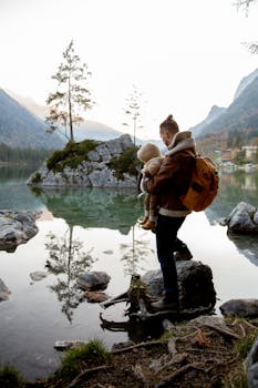 Father with child by a serene lake in autumn. Perfect for family adventure themes.