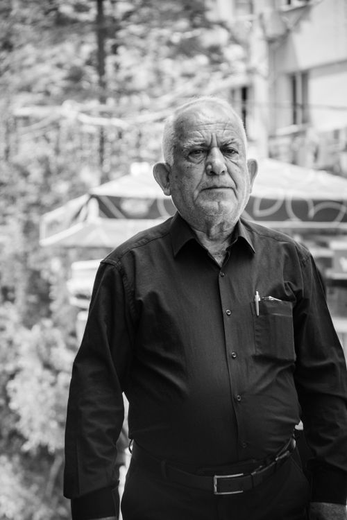 Free Black and white portrait of an elderly man in a black shirt standing outdoors. Stock Photo