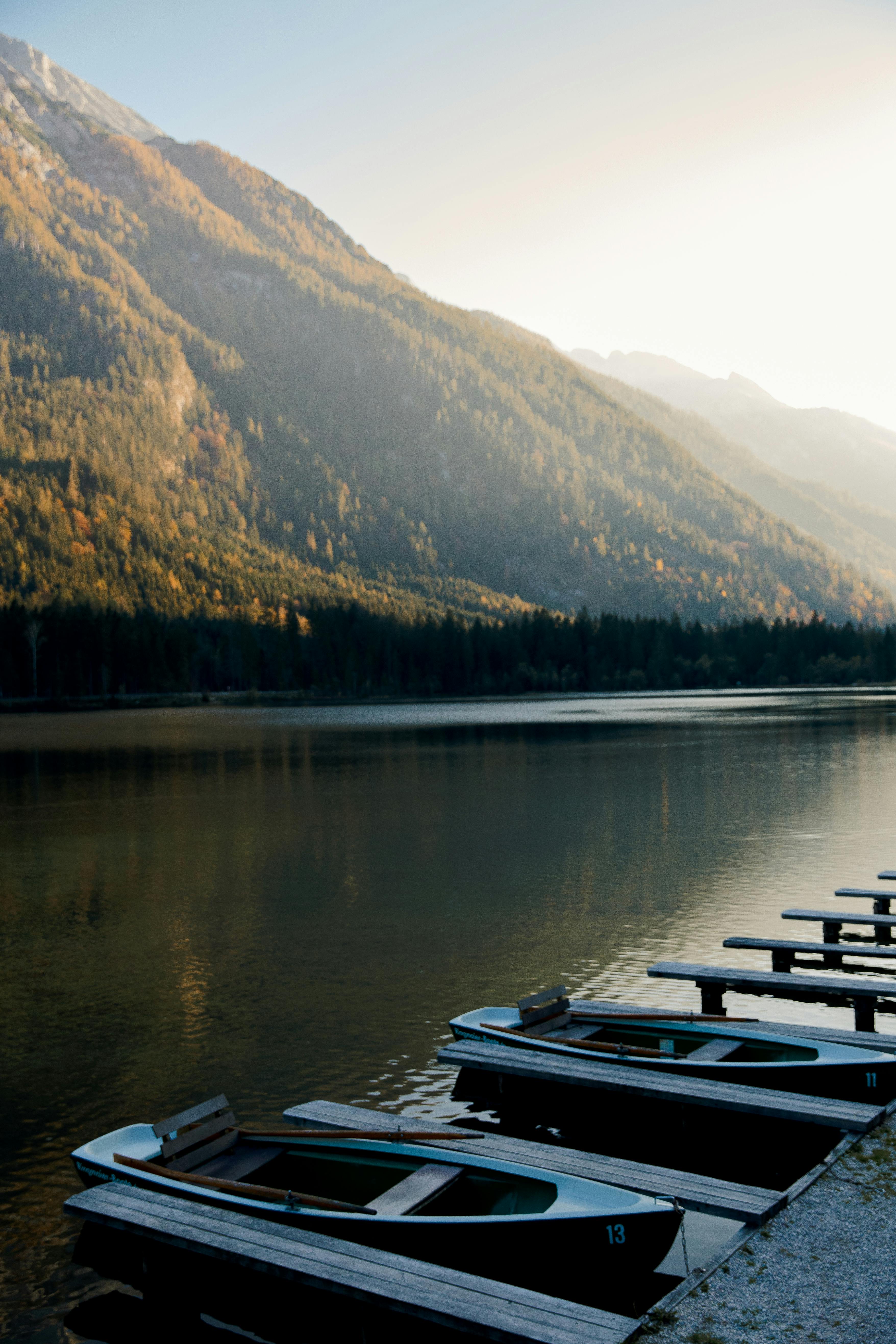 群山环绕的湖面风景秀丽，晴朗的天空下停靠着几艘划艇