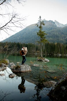 一位父亲带着他的孩子在风景秀丽的岩石湖边欣赏山景