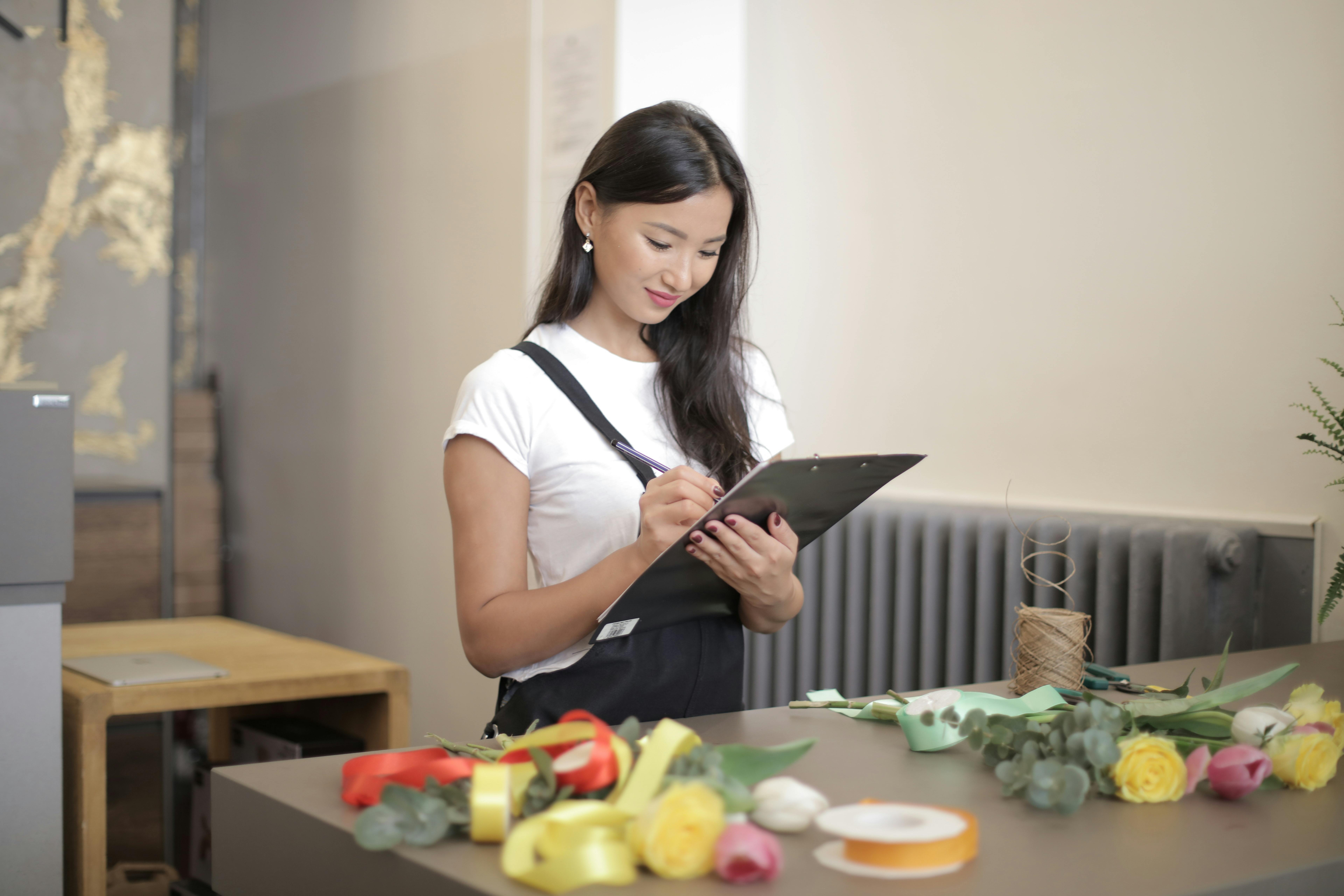 woman in white shirt holding black clipboard