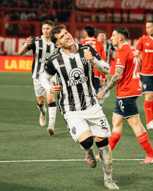 Free Soccer player in black stripes celebrates a goal on the field during a match. Stock Photo