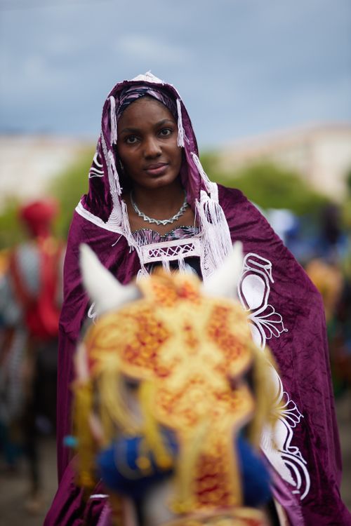 Free A woman in vibrant traditional African clothing participates in a cultural festival outdoors. Stock Photo