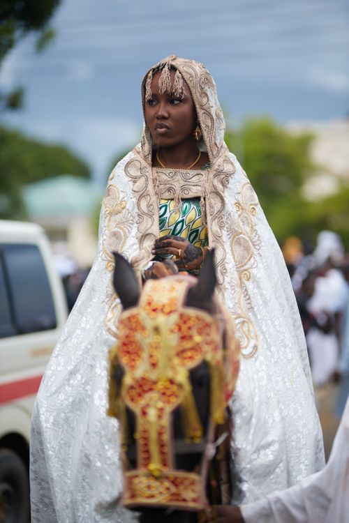 Free A woman in elaborate attire rides a decorated horse during a cultural event. Stock Photo