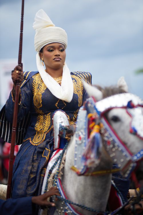 Free A woman in traditional attire riding a decorated horse at a cultural festival. Stock Photo