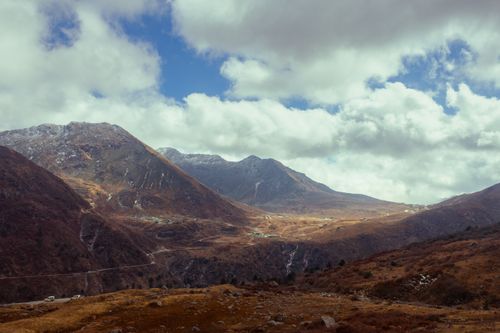 Free Scenic view of lush mountains in Sikkim, India with cloudy skies and rugged terrain. Stock Photo