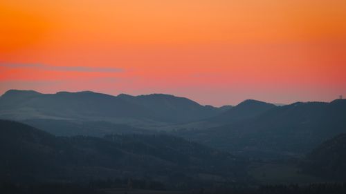 Free Serene mountain range bathed in a golden sunrise with vibrant sky colors. Stock Photo