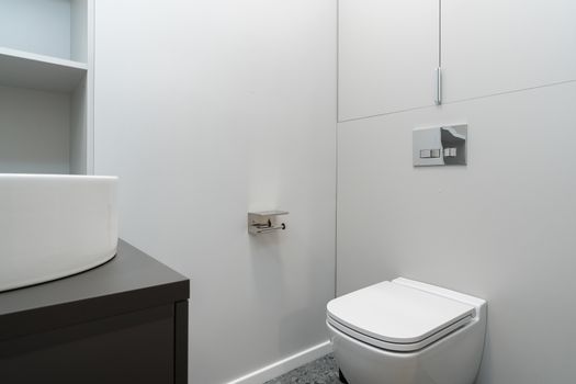 Sleek minimal bathroom showcasing a modern wall-mounted toilet and basin.