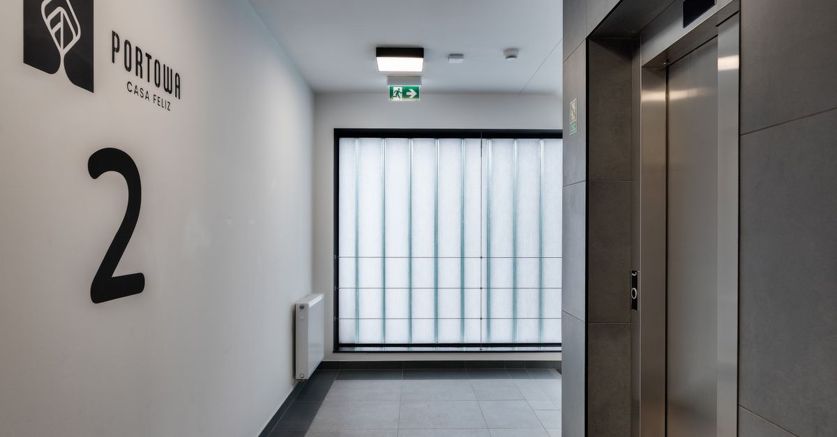 Sleek and minimalist apartment hallway with elevator and modern design.