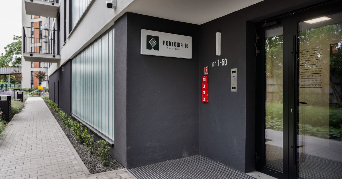 Entrance of a modern apartment building with number and signage.