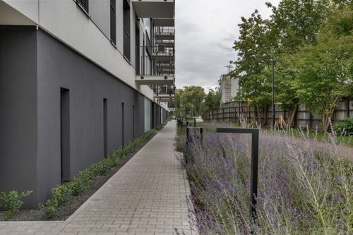 Free Exterior view of a modern apartment building with a landscaped garden path. Stock Photo
