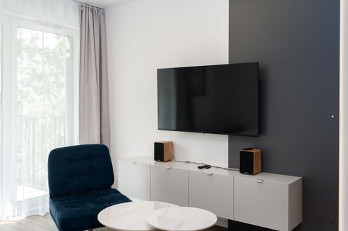 Free Contemporary living room featuring a sleek wall-mounted TV and stylish decor. Stock Photo