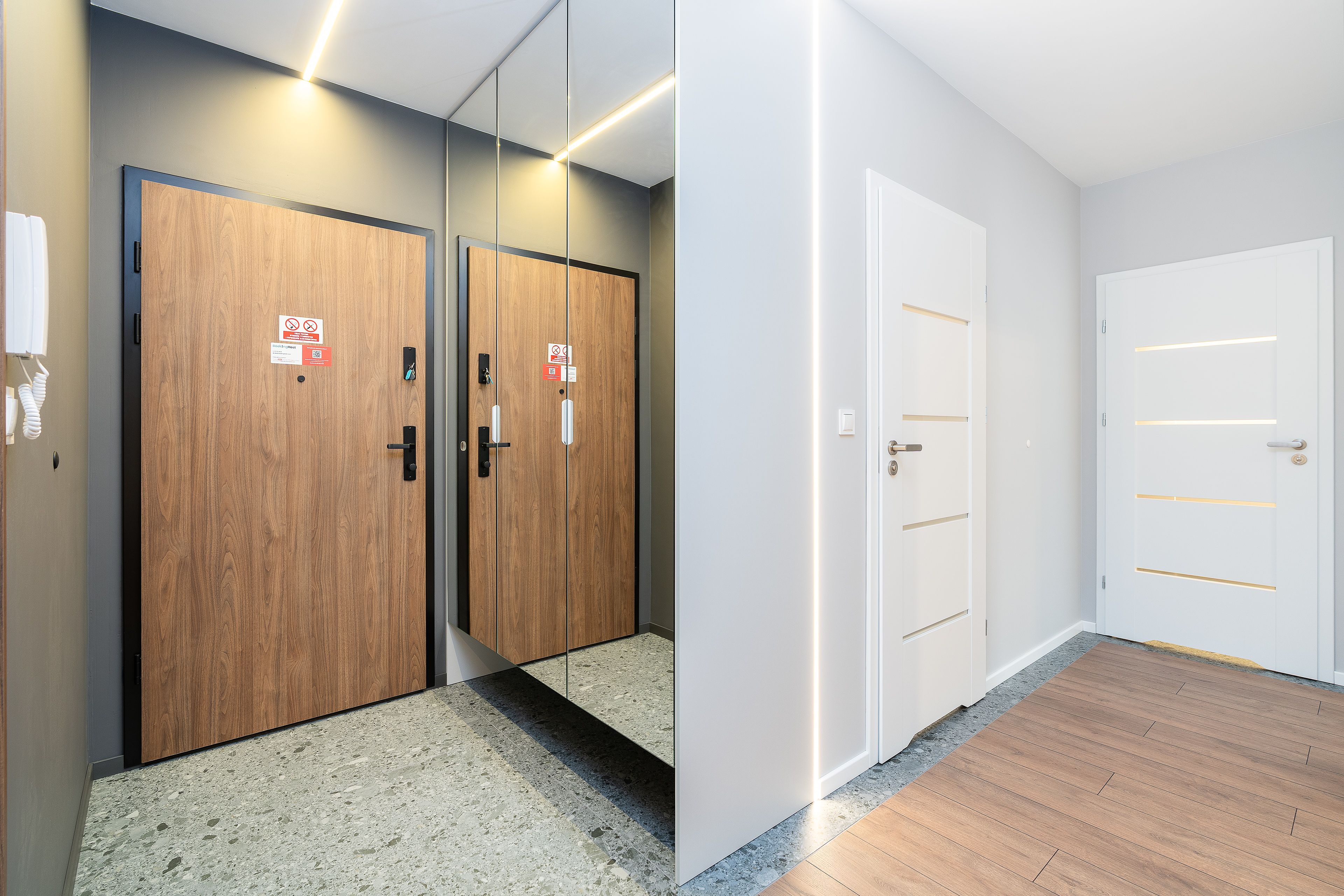 A hallway of finished apartment unit doors with unit numbers, ready for turnover walks