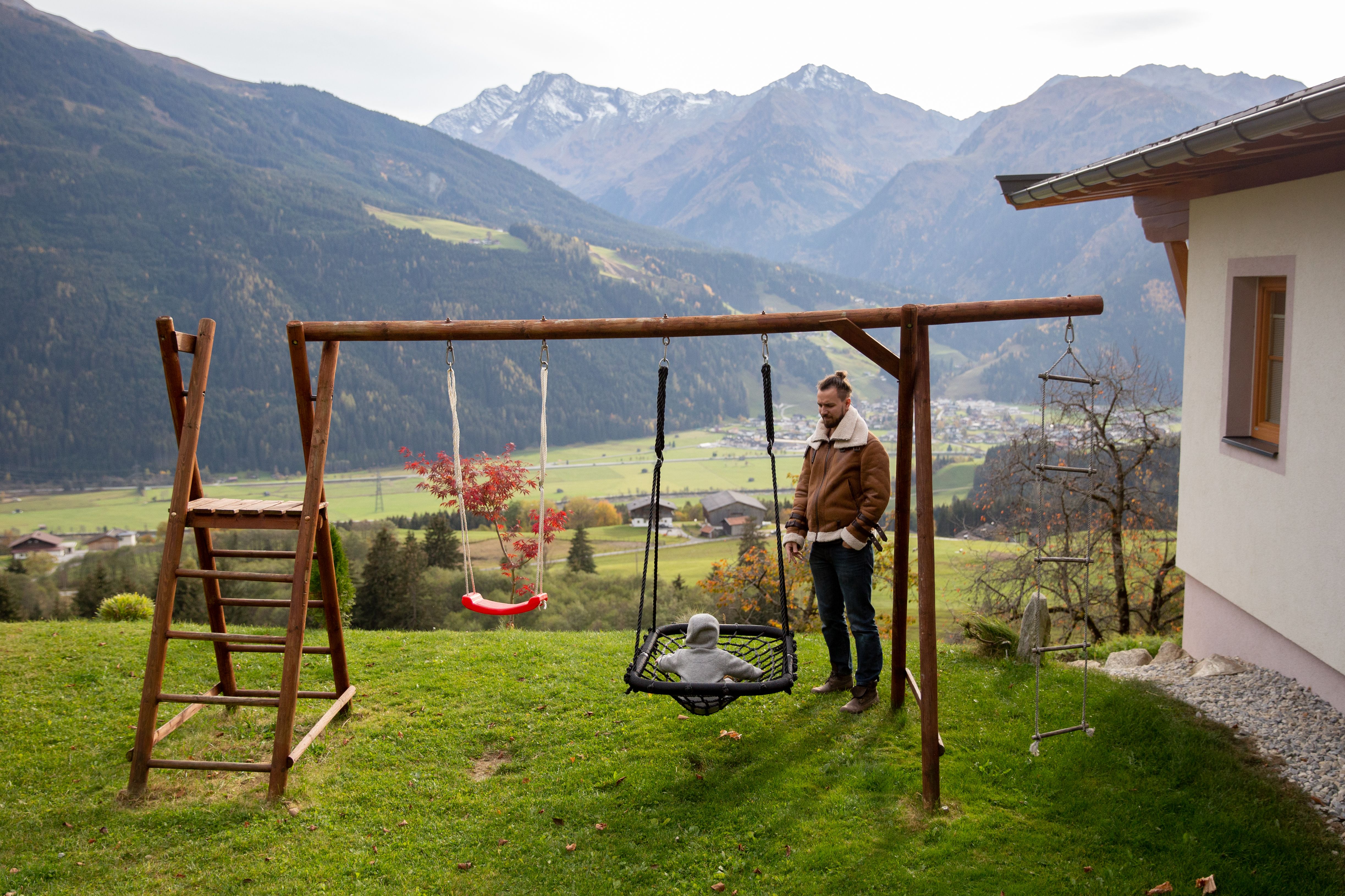 Brown Wooden Swing on Green Grass Field Near Mountains