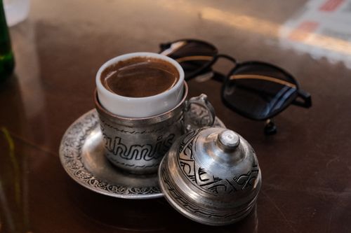 Free Authentic Turkish coffee in ornate silver cup on reflective surface. Stock Photo