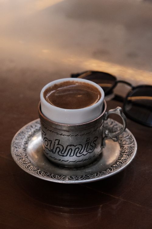 Free Elegant presentation of Turkish coffee in an ornate silver cup and saucer, symbolizing rich cultural heritage. Stock Photo