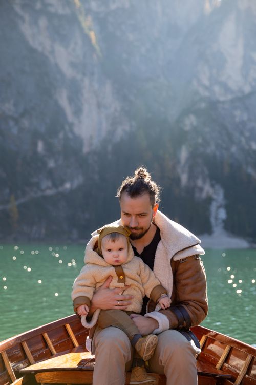 Free A father and child embrace on a boat surrounded by scenic lake views, enjoying leisure time outdoors. Stock Photo