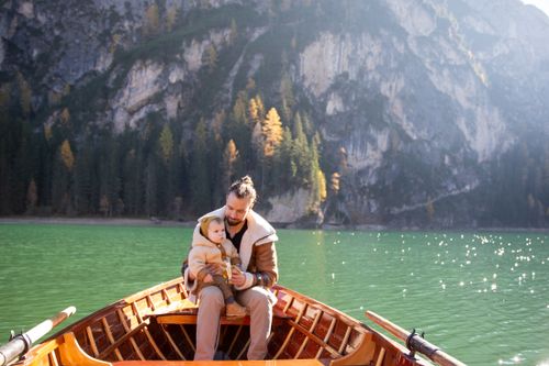 Free A serene moment of a father and baby enjoying a scenic boat ride on a lake. Stock Photo