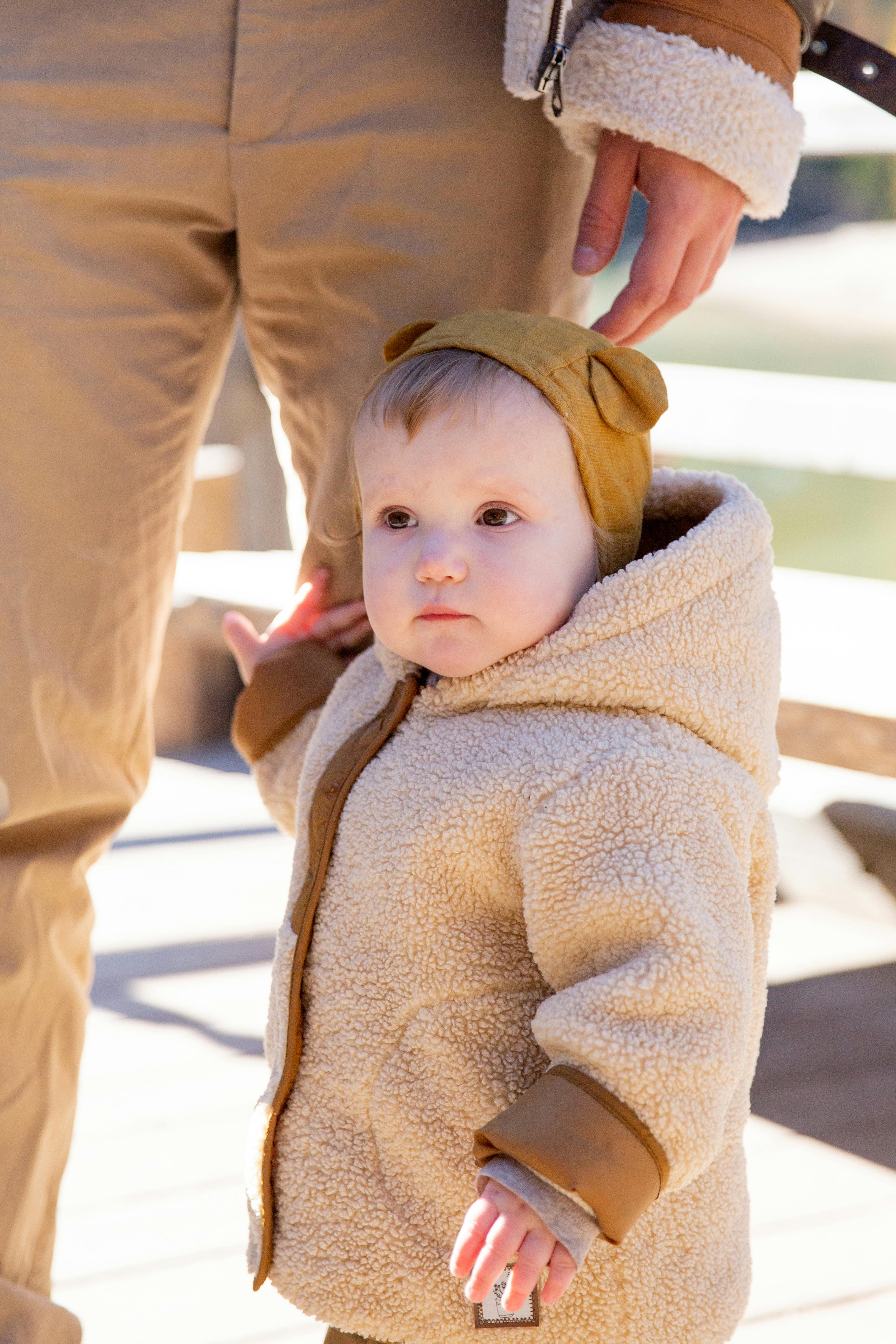 baby in brown sweater standing