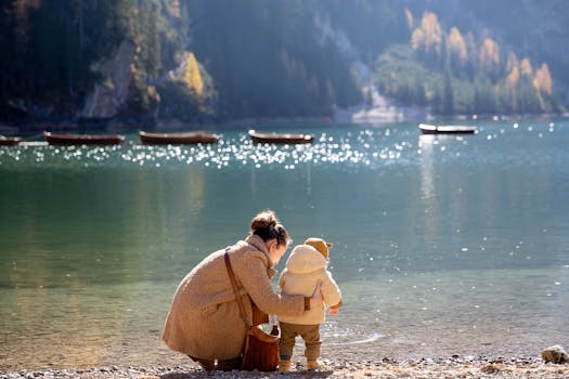 一个母亲和孩子在宁静的山湖边，乘船享受阳光明媚的日子