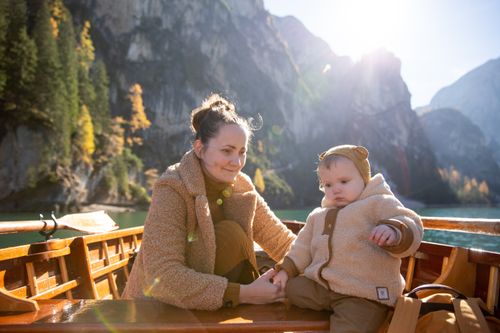 Free A mother and child enjoy a serene boat ride surrounded by mountains and nature, reflecting love and tranquility. Stock Photo