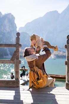 父亲和孩子在风景如画的湖边木制码头上相聚，四周群山环绕