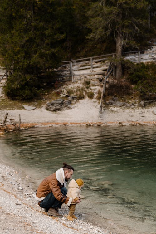 Free Father and Child Near Body of Water Stock Photo