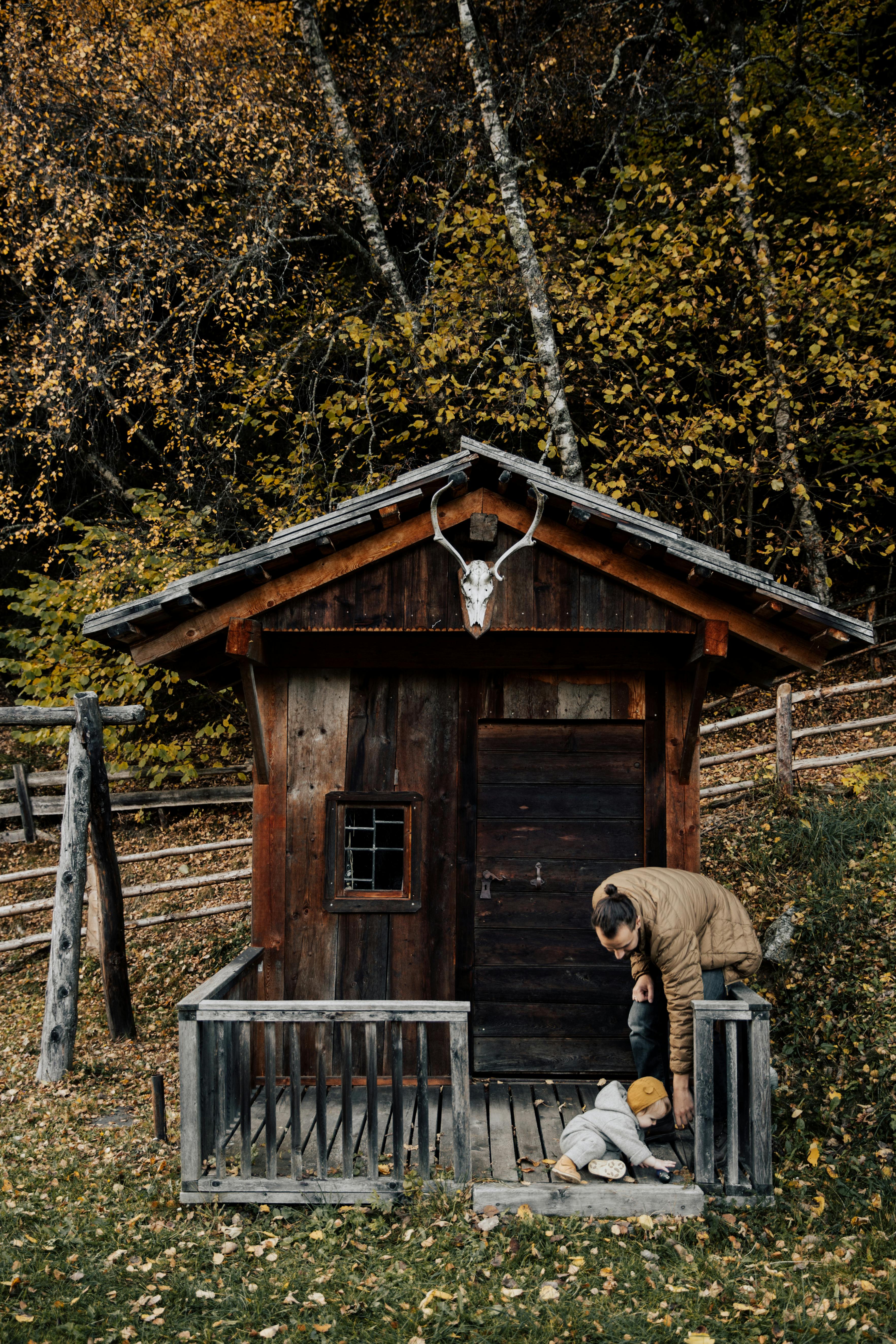 photo of man sitting on wooden fence