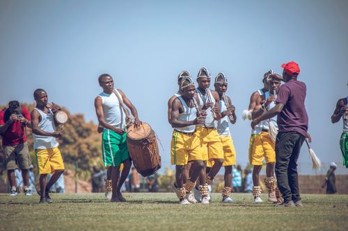 Free Group of men performing traditional African dance and music outdoors. Stock Photo
