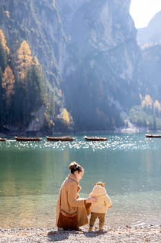 在风景秀丽的山湖边，一位母亲和孩子在秋天享受着宁静的时刻