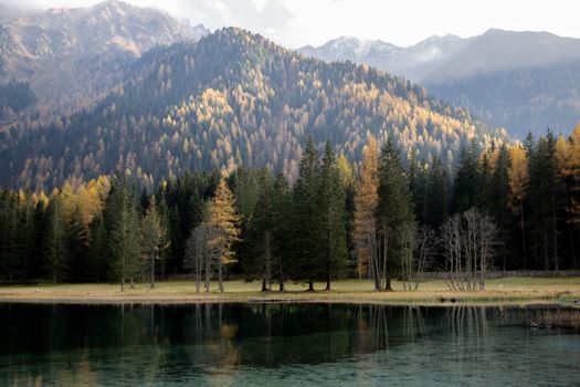 宁静的山景、平静的湖泊与充满活力的秋色倒映在水面上