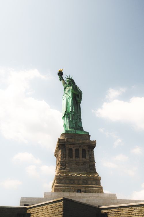 Free The Statue of Liberty under a clear blue sky in New York, representing freedom and democracy. Stock Photo