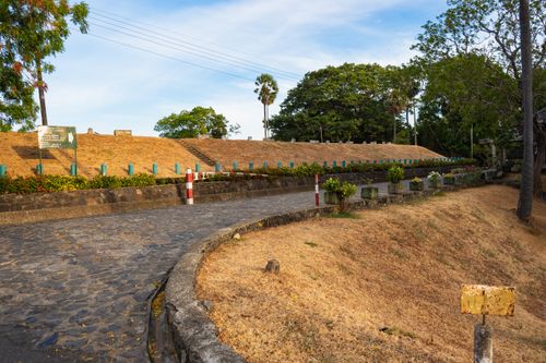 Free Scenic view of a historic pathway in Polonnaruwa with lush greenery and ancient architecture. Stock Photo